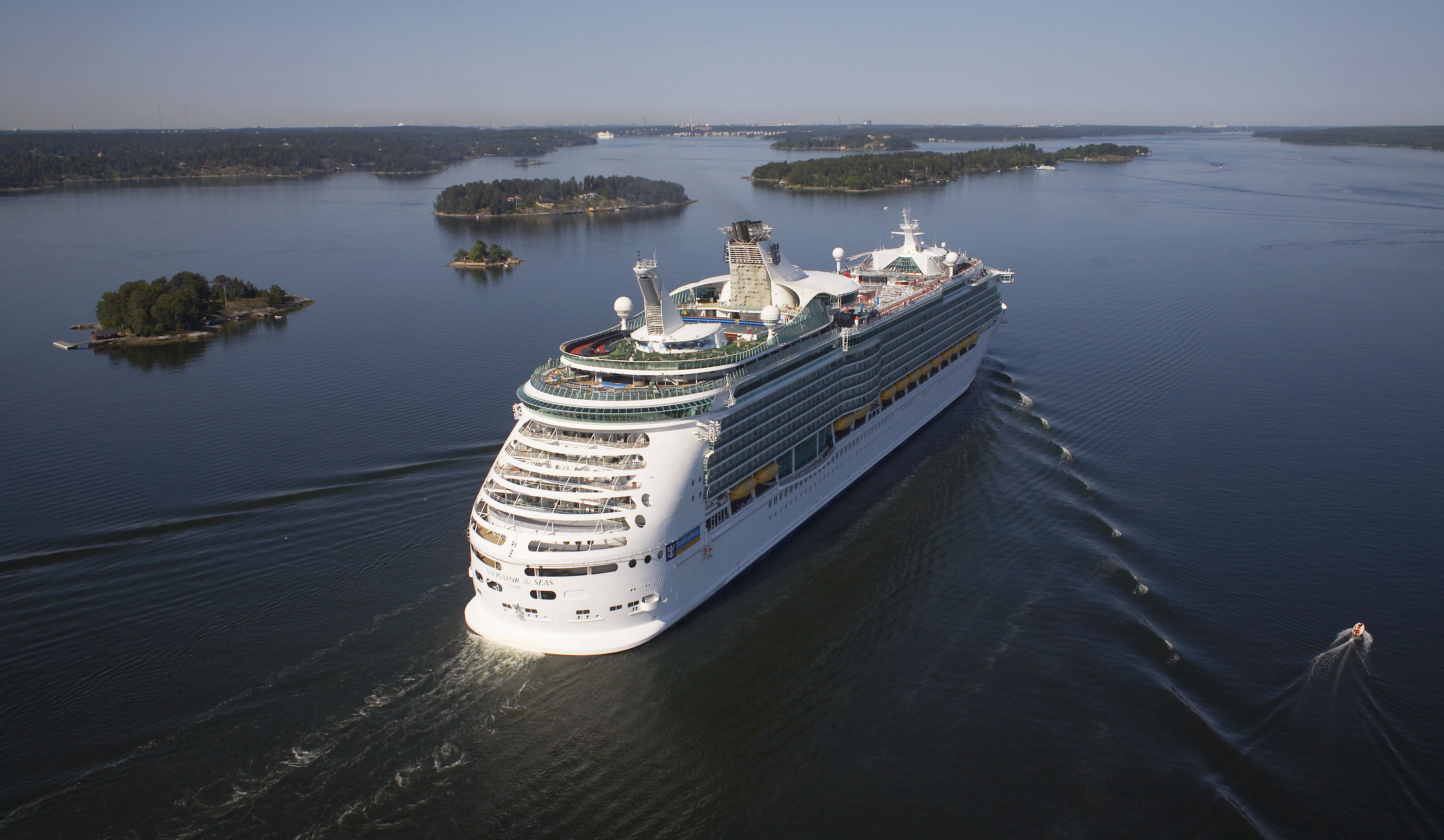 Ett stort kryssningsfartyg som seglar genom skärgården.