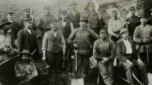 Stockholms kolbärare och gårdsarbetarelag vid Olaus Olssons kolgård vid Värtan. Ett stort antal män i arbetskläder - svartvit bild